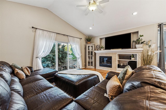 living room with ceiling fan, wood-type flooring, a fireplace, and lofted ceiling