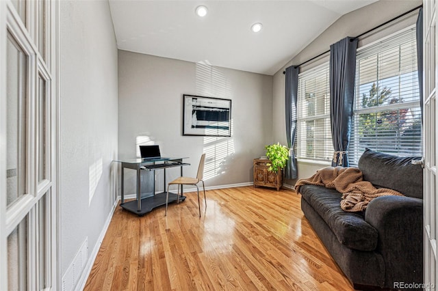 home office featuring light wood-type flooring and vaulted ceiling