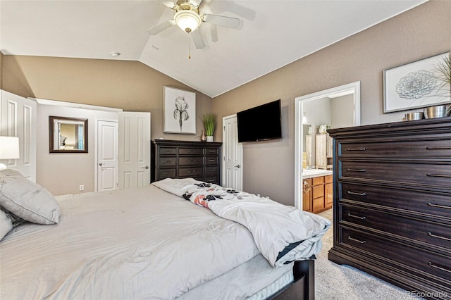 bedroom with ceiling fan, ensuite bathroom, light carpet, and vaulted ceiling