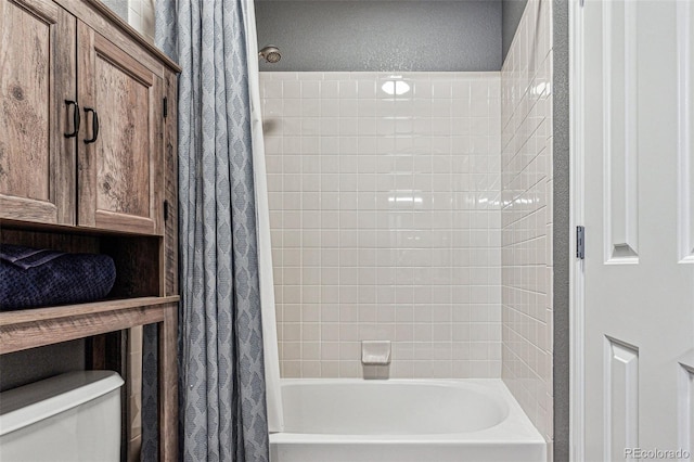 bathroom with shower / bath combination with curtain and toilet