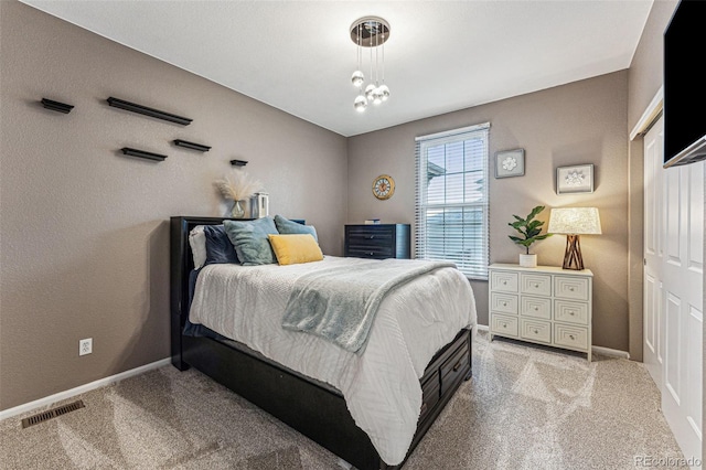 bedroom with an inviting chandelier and light colored carpet