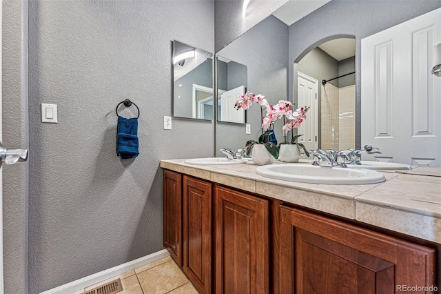 bathroom featuring walk in shower, vanity, and tile patterned floors