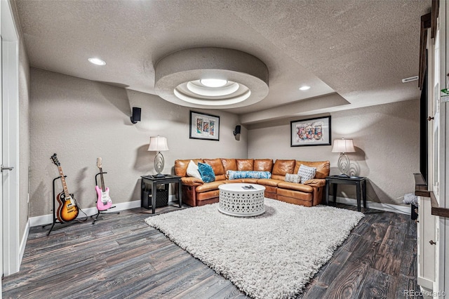 living room with a tray ceiling, a textured ceiling, and dark hardwood / wood-style flooring