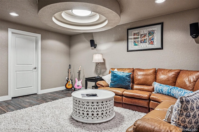 living room with a tray ceiling and dark hardwood / wood-style flooring