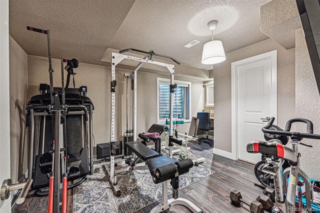 workout area with a textured ceiling and hardwood / wood-style floors