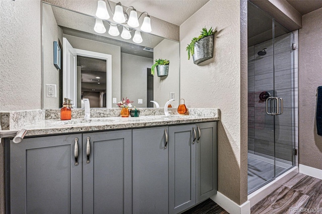 bathroom with hardwood / wood-style flooring, walk in shower, and vanity