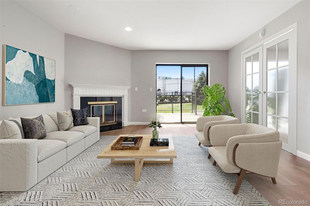 350 Detroit St Unit 107, Denver, CO 80206 - living room featuring baseboards, recessed lighting, a fireplace with flush hearth, and wood finished floors
