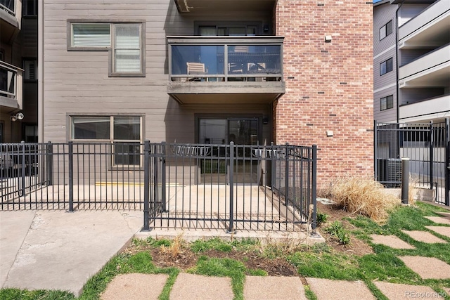 350 Detroit St Unit 107, Denver, CO 80206 - exterior space featuring a balcony, brick siding, fence, and a gate