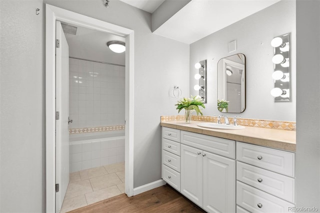 350 Detroit St Unit 107, Denver, CO 80206 - full bathroom with vanity, tiled shower / bath combo, and wood finished floors