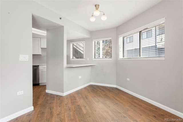350 Detroit St Unit 107, Denver, CO 80206 - empty room featuring wood finished floors, a chandelier, and baseboards