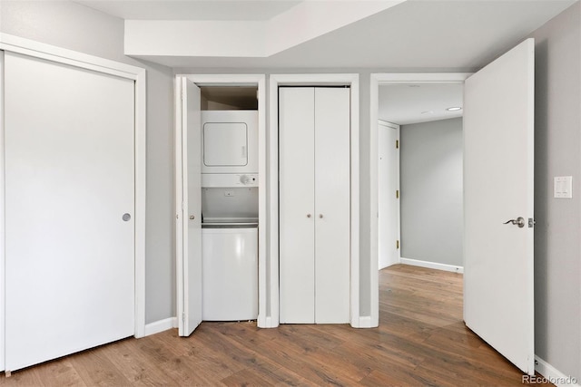 350 Detroit St Unit 107, Denver, CO 80206 - unfurnished bedroom with wood finished floors, baseboards, multiple closets, and stacked washer and dryer