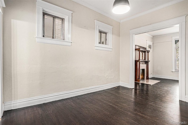 unfurnished room featuring baseboards, dark wood-style floors, ornamental molding, and a fireplace with flush hearth