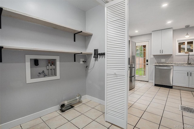 laundry room featuring baseboards, light tile patterned flooring, a sink, and recessed lighting
