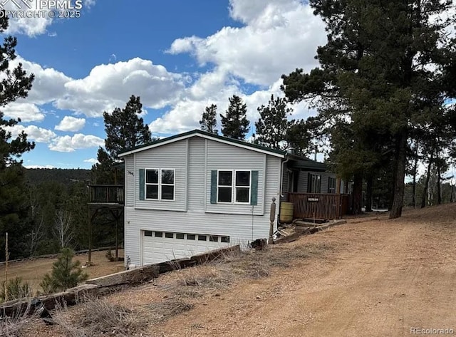 3647 Pathfinder Rd Unit B, Florissant, CO 80816 - view of front of property featuring dirt driveway, a garage, and a deck