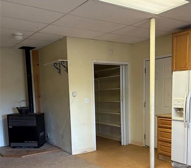 3647 Pathfinder Rd Unit B, Florissant, CO 80816 - unfurnished bedroom featuring white fridge with ice dispenser, a paneled ceiling, a closet, and a wood stove