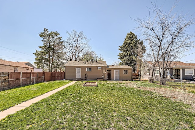 back of property featuring a fenced backyard and a yard