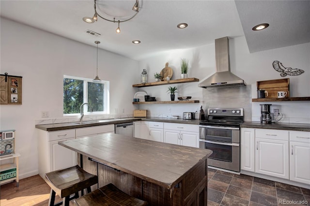 777 Deerview Dr, Florissant, CO 80816 - kitchen featuring wall chimney exhaust hood, open shelves, appliances with stainless steel finishes, dark countertops, and a sink
