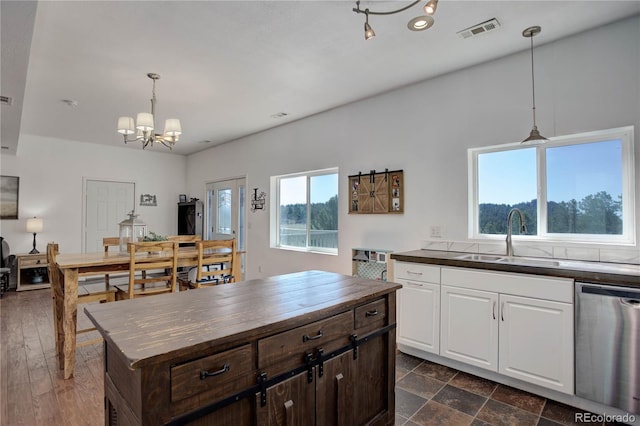 777 Deerview Dr, Florissant, CO 80816 - kitchen with stainless steel dishwasher, a sink, a chandelier, wood counters, and white cabinetry