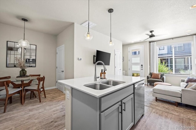 19592 W 93rd Pl Unit C, Arvada, CO 80007 - kitchen featuring gray cabinetry, stainless steel appliances, light wood finished floors, open floor plan, and light countertops