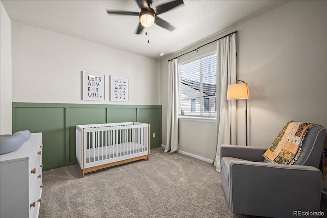 19592 W 93rd Pl Unit C, Arvada, CO 80007 - bedroom with carpet flooring, a wainscoted wall, a crib, and ceiling fan