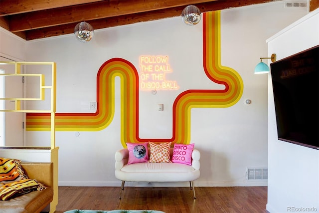 interior space featuring visible vents, beam ceiling, baseboards, and wood finished floors