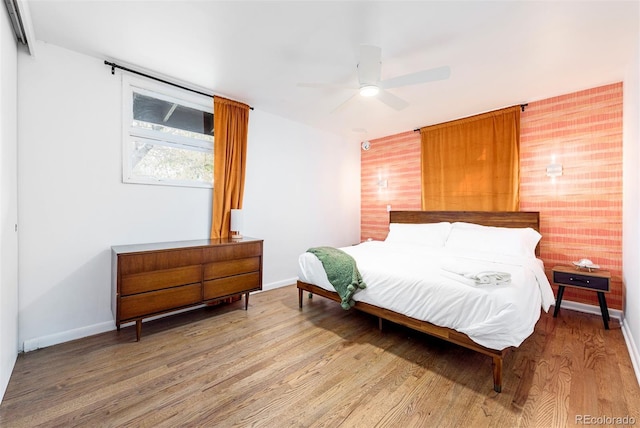 bedroom featuring ceiling fan, baseboards, and wood finished floors