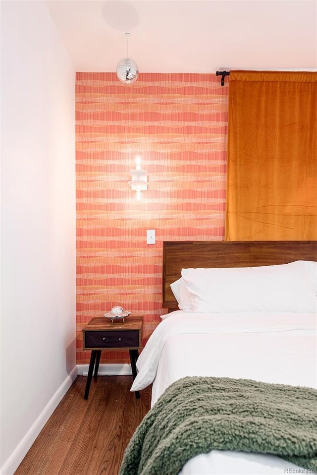 bedroom with baseboards and wood finished floors