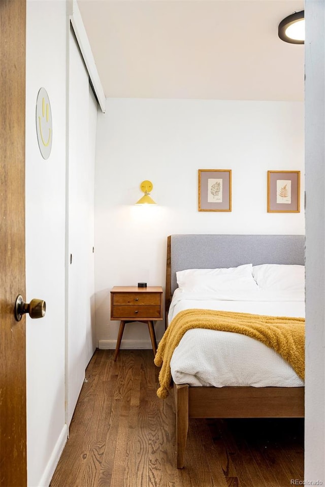 bedroom featuring a closet, baseboards, and wood finished floors