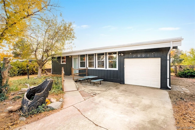 ranch-style house with board and batten siding, concrete driveway, and a garage