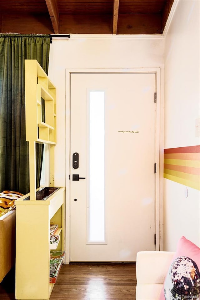 doorway to outside with beam ceiling, wood ceiling, and wood finished floors