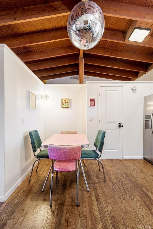 dining area featuring wooden ceiling, lofted ceiling with beams, wood finished floors, and baseboards