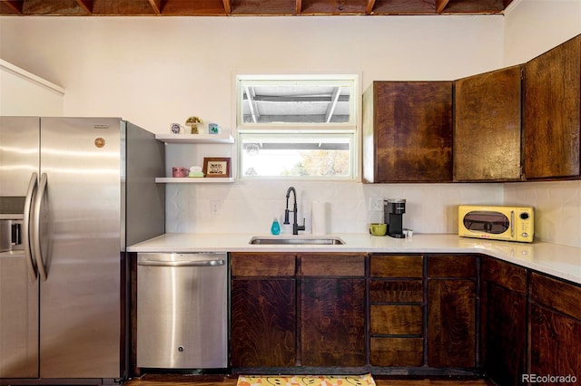 kitchen with a sink, stainless steel appliances, light countertops, dark brown cabinets, and tasteful backsplash