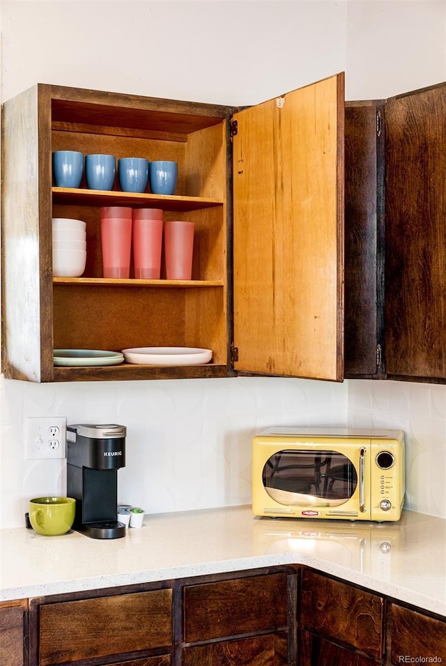 kitchen with tasteful backsplash, light countertops, and open shelves