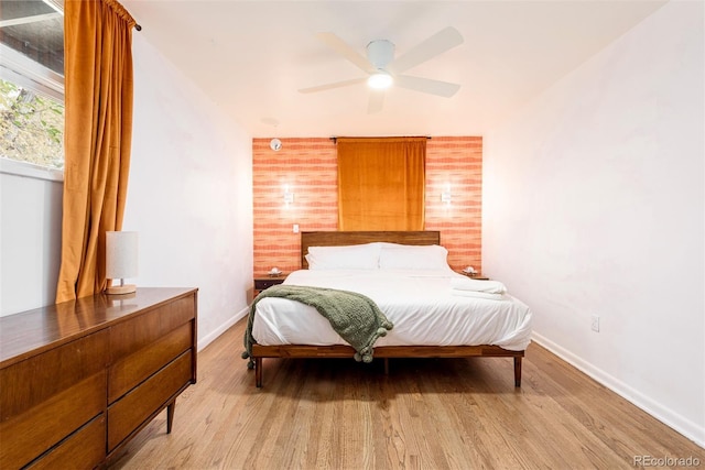 bedroom with light wood finished floors, ceiling fan, and baseboards