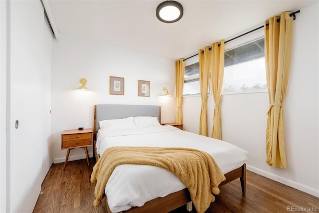 bedroom with baseboards and wood finished floors