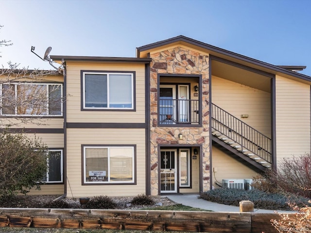 multi unit property featuring stone siding and stairway