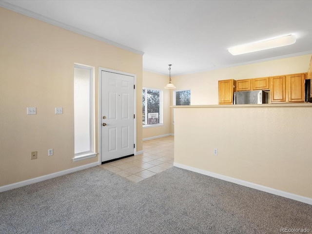 interior space with light tile patterned flooring, light colored carpet, crown molding, and baseboards