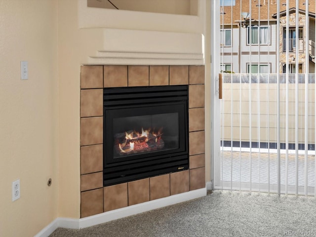 interior details with carpet flooring, a tile fireplace, and baseboards