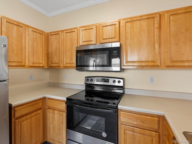 kitchen featuring light countertops, appliances with stainless steel finishes, and ornamental molding