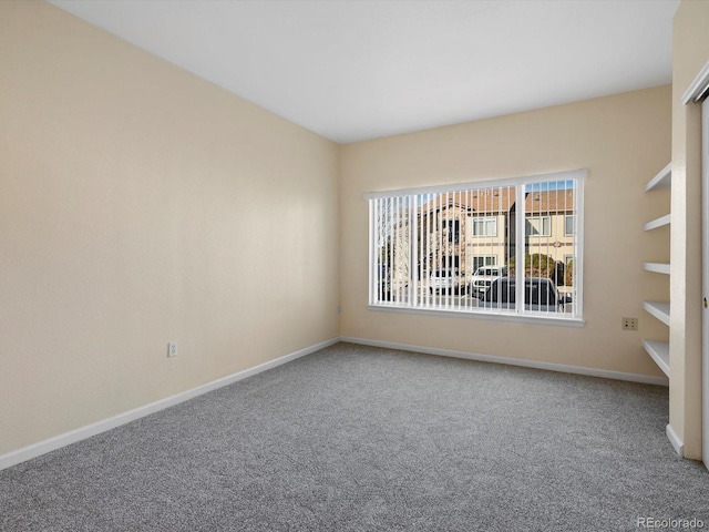 unfurnished room featuring baseboards and carpet