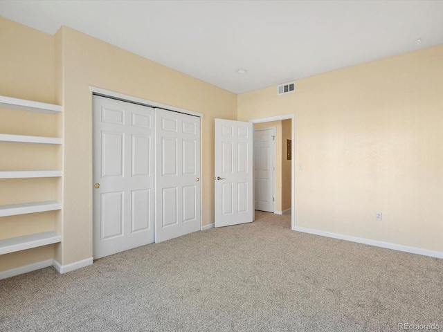 unfurnished bedroom with a closet, baseboards, visible vents, and carpet floors