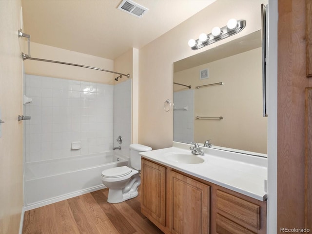 bathroom featuring visible vents, toilet, wood finished floors, bathing tub / shower combination, and vanity