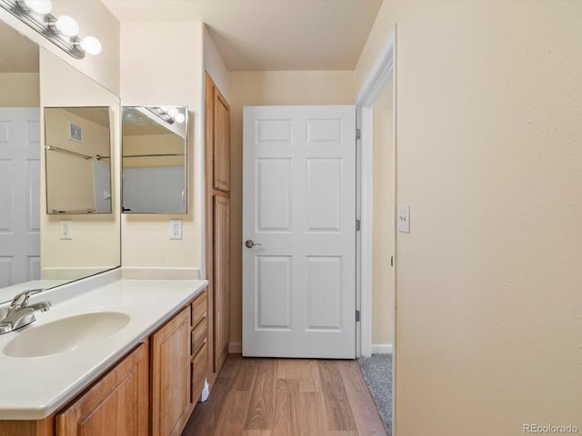 bathroom with vanity, baseboards, and wood finished floors