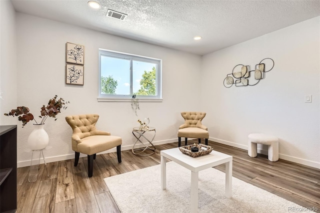 17979 E Oxford Pl, Aurora, CO 80013 - living area with wood finished floors, a textured ceiling, baseboards, and recessed lighting