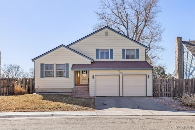 tri-level home with fence, a garage, and driveway