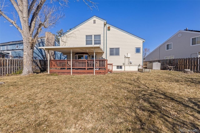 back of property featuring a fenced backyard, a lawn, and a wooden deck