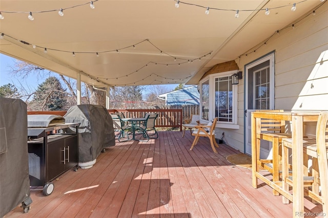 wooden terrace with outdoor dining space and grilling area