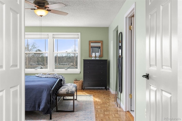 bedroom with ceiling fan, a textured ceiling, and baseboards