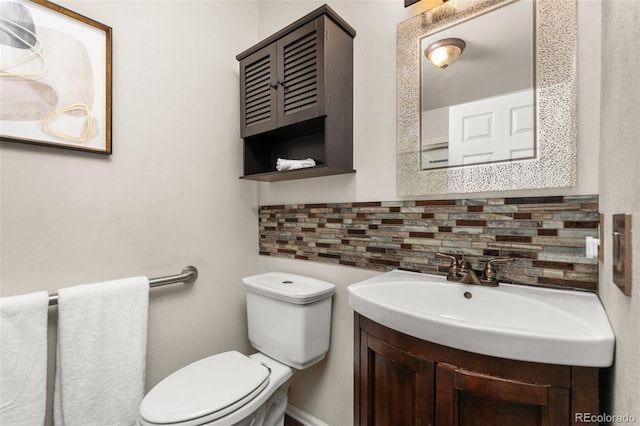 half bathroom featuring tasteful backsplash, toilet, and vanity