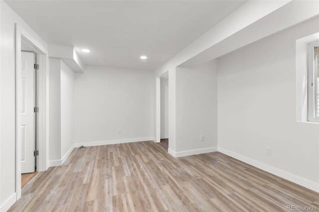 below grade area featuring light wood-style flooring, recessed lighting, and baseboards